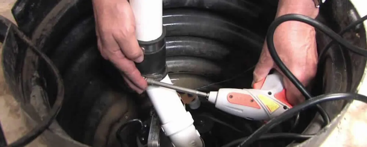 Sump pump installation technician connecting PVC discharge piping in Duluth, MN